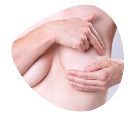 Eine Frau tastet ihr linke Brust ab.