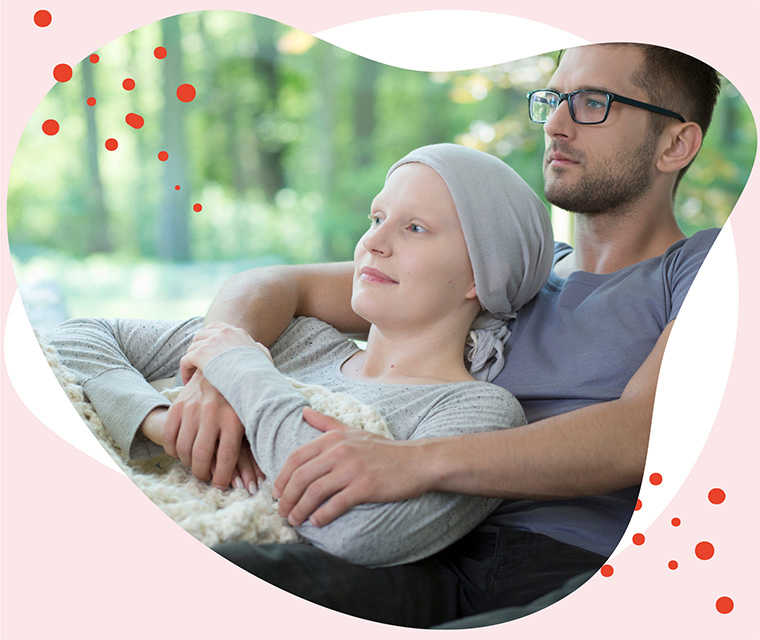 Leben mit Brustkrebs: Ein Paar liegt Arm in Arm auf dem Sofa nach der Chemotherapie der Frau