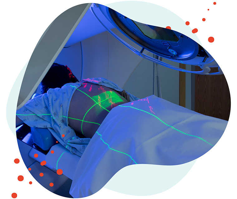Leben mit Brustkrebs: Patientin liegt unter einem Screening Leben mit Brustkrebs: Patientin liegt unter einem Screening