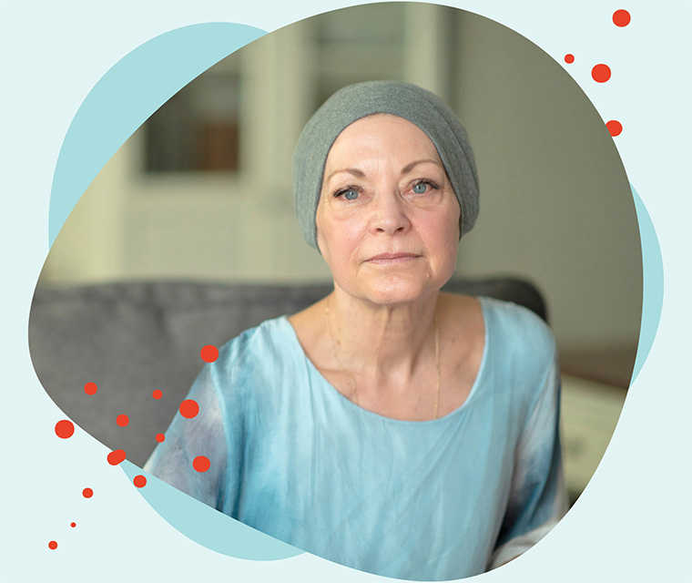 Leben mit Brustkrebs: Patientin schaut in die Kamera und bedeckt ihren Kopf mit einer Mütze