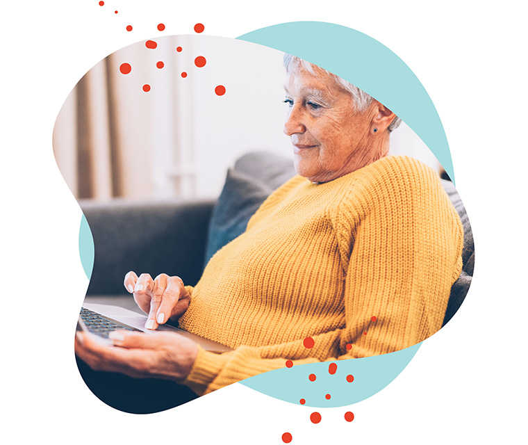 Leben mit Brustkrebs: Ältere Dame schaut etwas auf ihrem Laptop nach