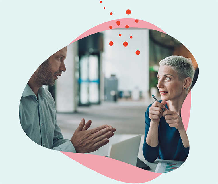 Leben mit Brustkrebs: Eine kurzhaarige Frau im Gespräch mit einem Kollegen