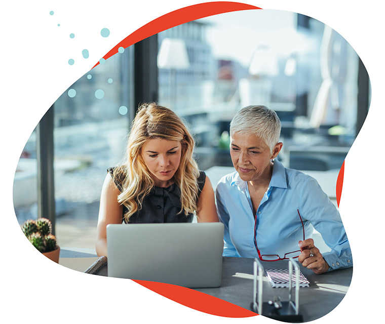 Leben mit Brustkrebs: Zwei Frauen arbeiten zusammen an einem Laptop