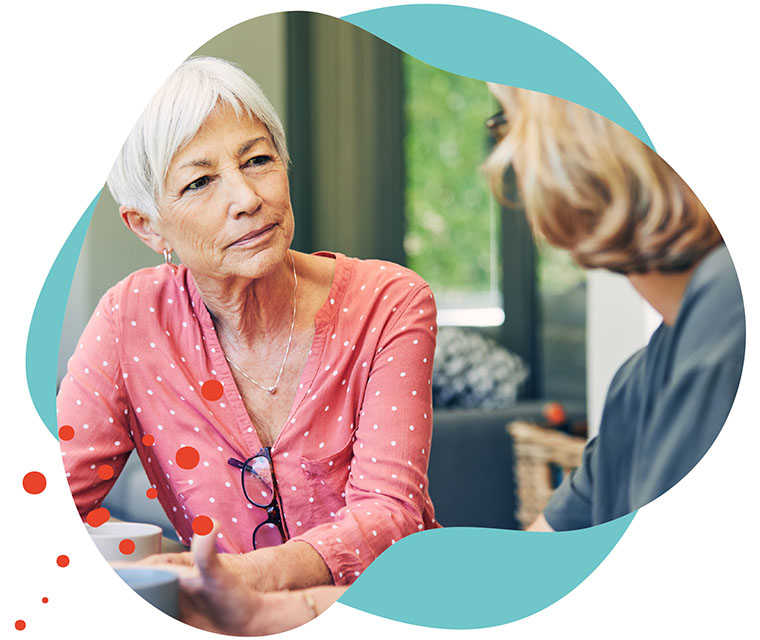 Leben mit Brustkrebs: Zwei Frauen unterhalten sich in einem Cafe