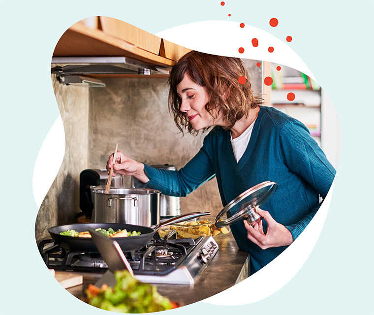 Leben mit Brustkrebs: Eine brünette Frau rührt beim Kochen in einem Kochtopf