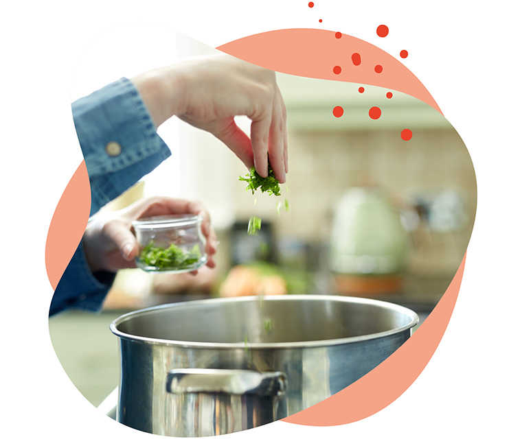 Leben mit Brustkrebs: Nahaufnahme von einem Kochtopf in den Gewürze geworfen werden