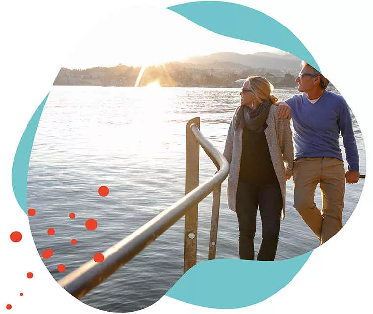 Leben mit Brustkrebs: Ein älteres Paar steht zusammen am Wasser