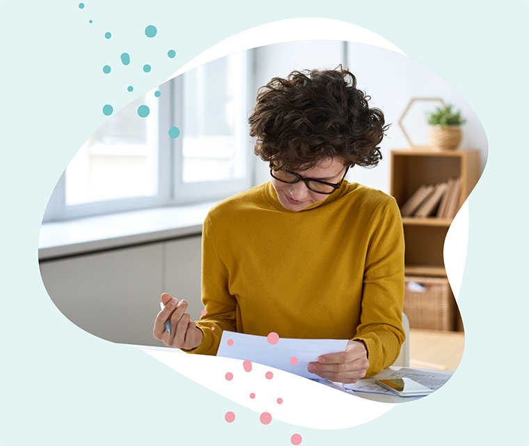 Leben mit Brustkrebs: Eine Frau liest und unterschreibt ein paar Dokumente