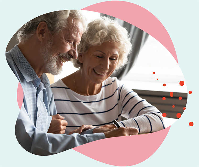 Leben mit Brustkrebs: Ein älteres Paar unterschreibt fröhlich ein Dokument