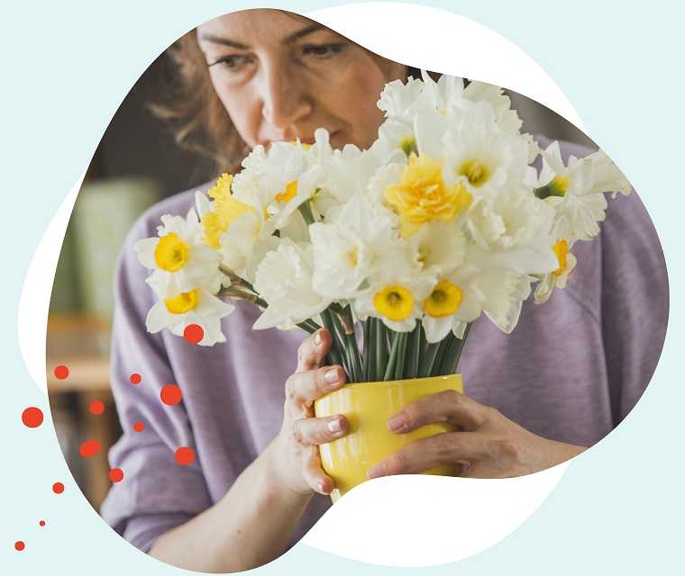 Leben mit Brustkrebs: Eine brünette Frau hält einen Blumenstrauß in der Hand Leben mit Brustkrebs: Eine brünette Frau hält einen Blumenstrauß in der Hand