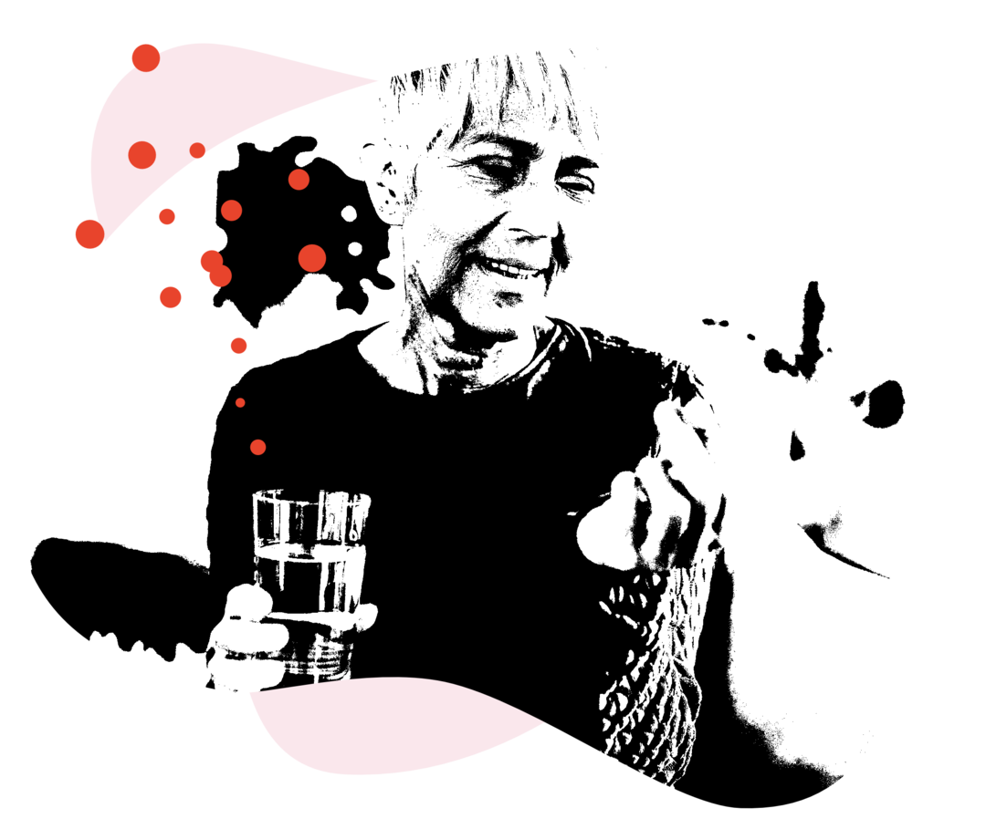 Eine Frau hält in der einen Hand eine Tablette, in der anderen Hand ein Glas mit Wassrr.