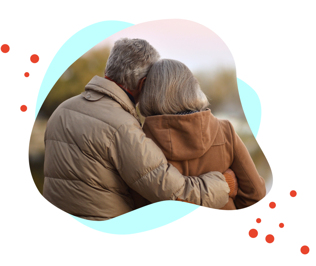 Rückansicht eines älteren Paares, das sich vertraut umarmt.