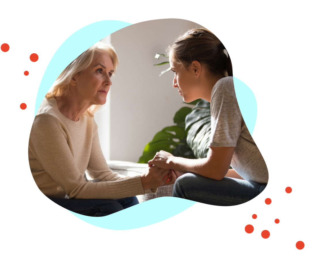 Eine ältere und ein jüngere Frau unterhalten sich ernst.