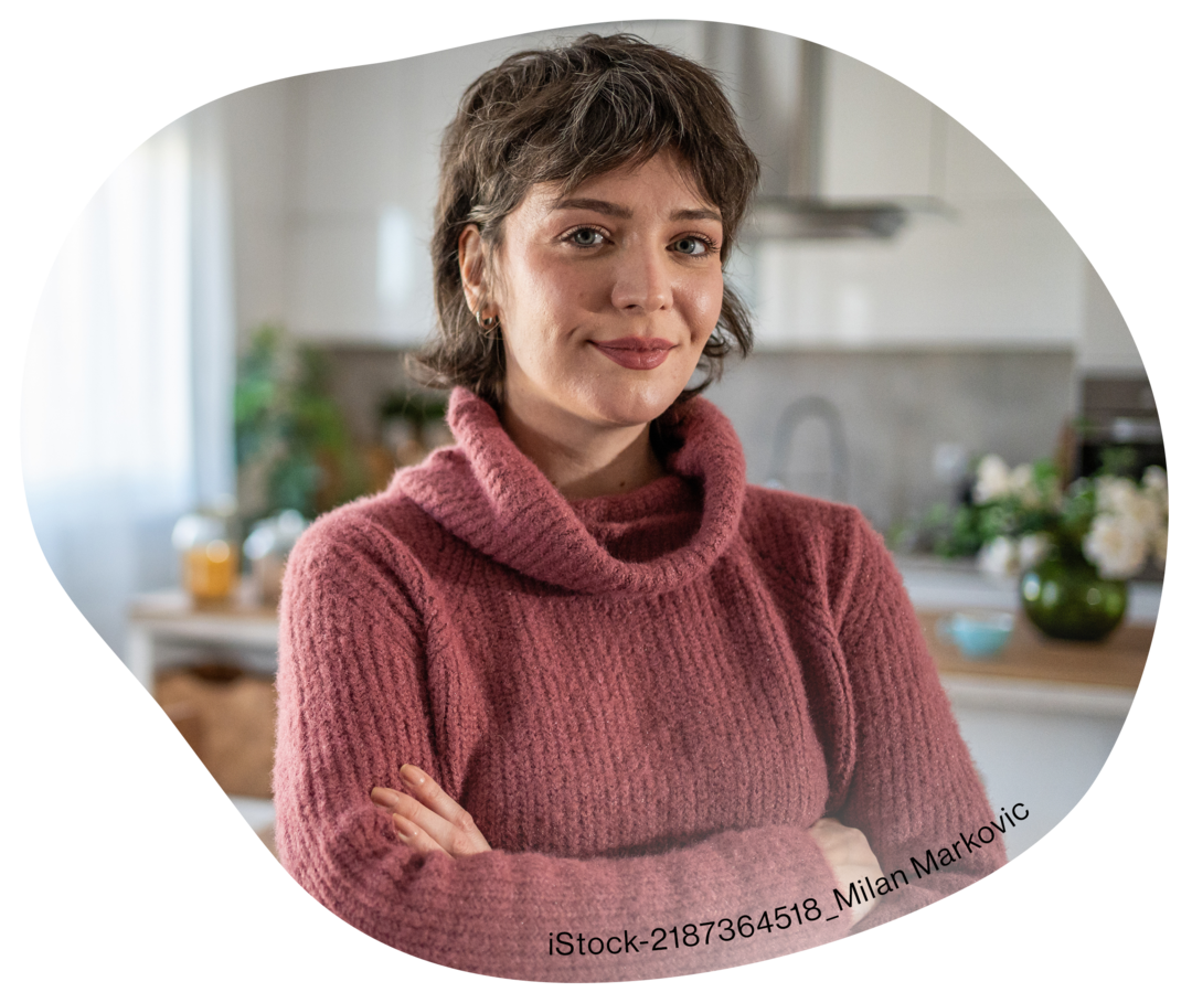  Eine Frau steht mit verschränkten Armen in einer Küche.